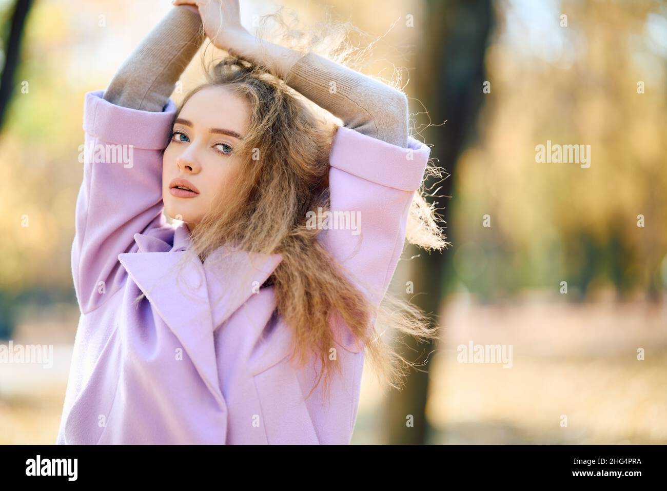 Ritratto di elegante bella donna in posa all'aperto in autunno parco godendo giorno di sole con spazio copia. Concetto di stagione autunnale, emozioni, bellezza femminile Foto Stock