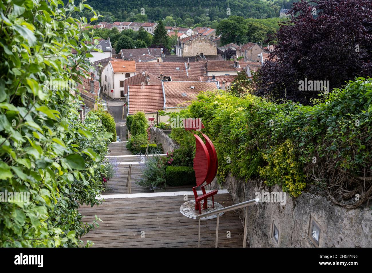 Liverdun, Francia - 27 giugno 2020: Strada con scale a Liverdun in Francia con vecchie case, foresta e arte sulle scale. Foto Stock