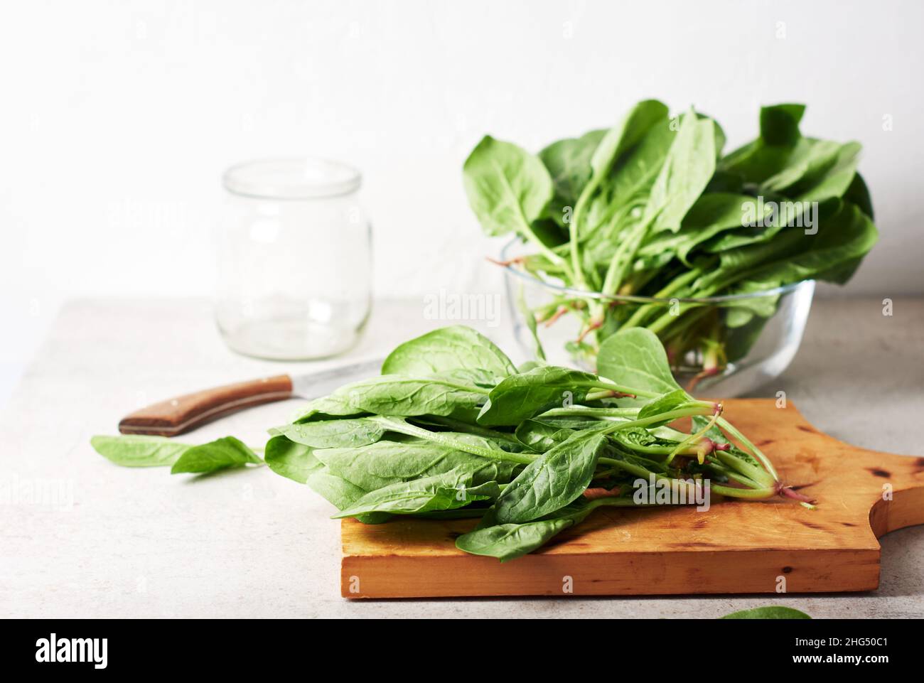 Foglie di spinaci freschi verdi su un tagliere. Foto Stock