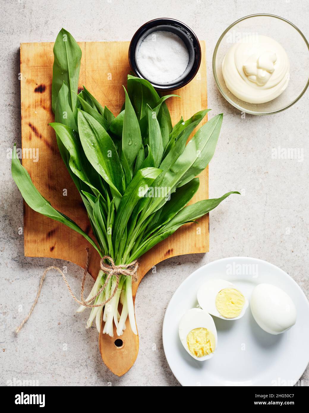 Mazzo di ramson fresco (aglio selvatico), salsa maionese, uova. Ingredienti per un'insalata o un antipasto. Foto Stock