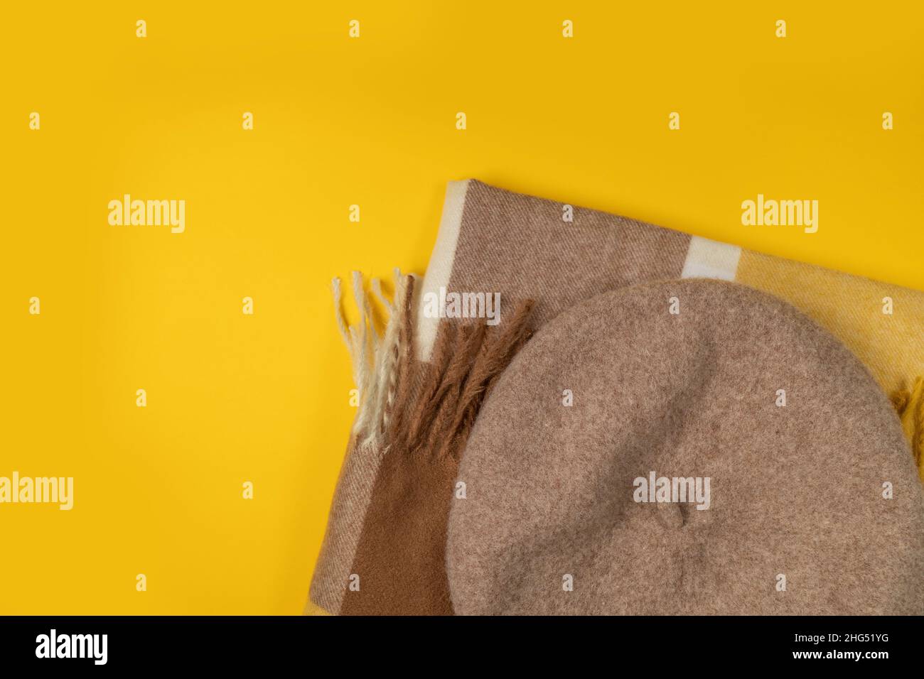 Shopping autunnale, vendita autunnale, promozione, sconto. Berretto in feltro di lana, sciarpa gialla su sfondo giallo brillante Foto Stock