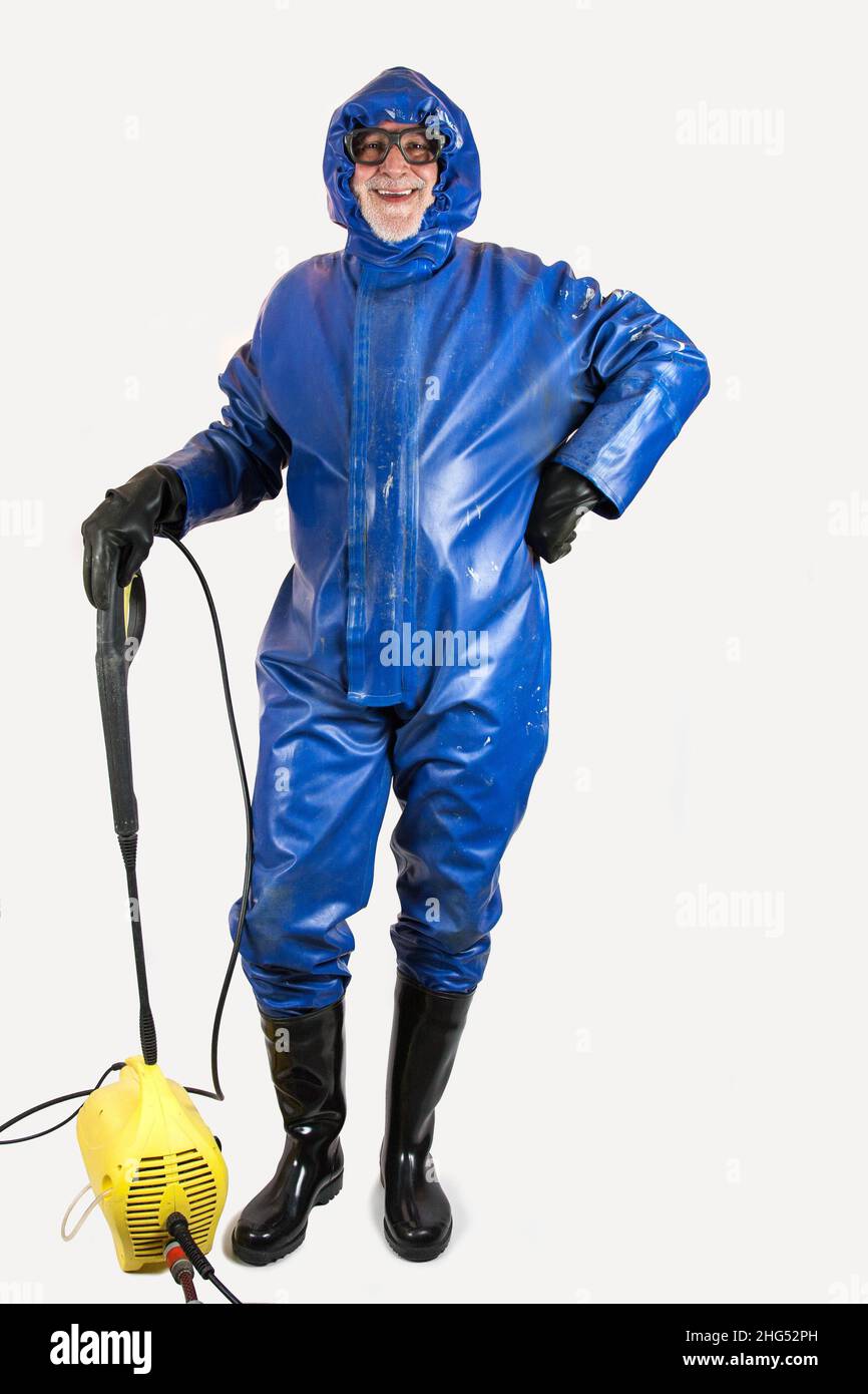 Pronto per la pulizia ad alta pressione. Un uomo da lavoro in tuta protettiva, guanti di gomma, stivali di gomma e occhiali di protezione è pronto per la pulizia con la sua pressione Foto Stock
