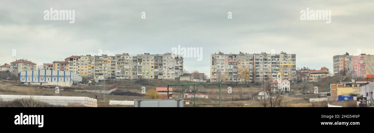 Vista panoramica di un blocco di complesso di appartamenti in cattive condizioni su una collina nel sud della Bulgaria durante la stagione invernale. La povertà nei dintorni Foto Stock