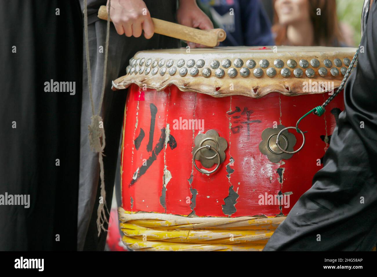 Palcoscenico che colpisce un tamburo giapponese rosso (taiko) Foto Stock