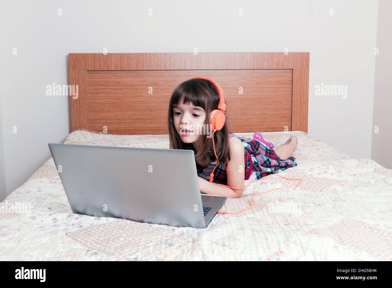 Bambina che usa il computer portatile con le cuffie Foto Stock