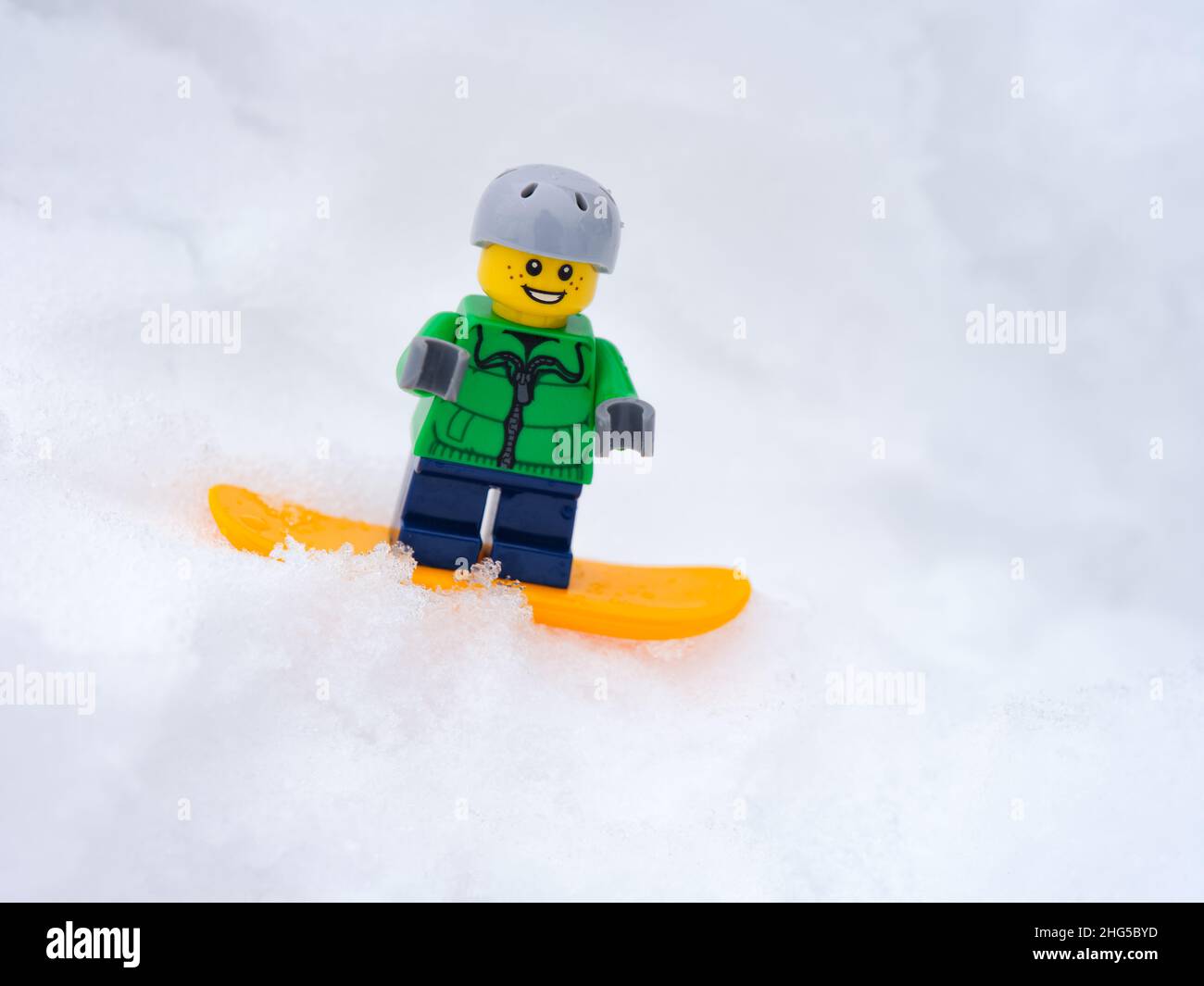 Tambov, Federazione russa - 18 gennaio 2022 una minipina di bambini Lego snowboarder snowboarder giù per una collina nevosa. Primo piano. Foto Stock