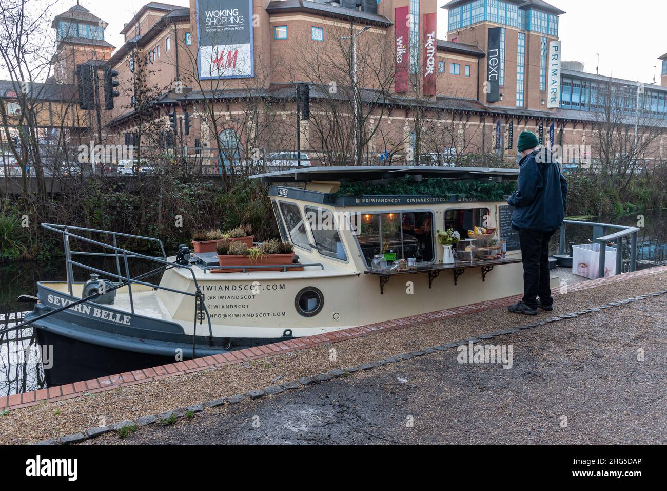 Kiwi e Scot cafe su una barca, Basingstoke Canal a Woking Town, Surrey, Inghilterra, Regno Unito, serve caffe' e torte durante l'inverno Foto Stock