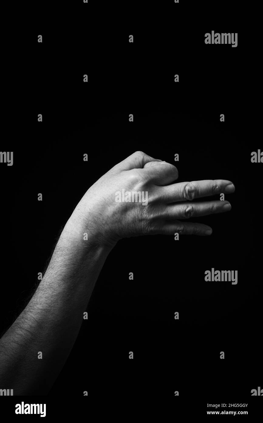 Immagine B+W drammatica del maschio mano Fingerspelling CSL cinese segno lingua lettera e isolato su sfondo scuro Foto Stock