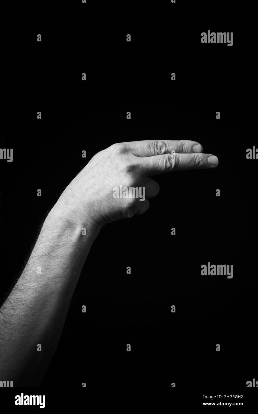 Immagine B+W drammatica del maschio mano Fingerspelling CSL cinese segno lingua lettera F isolato su sfondo scuro Foto Stock