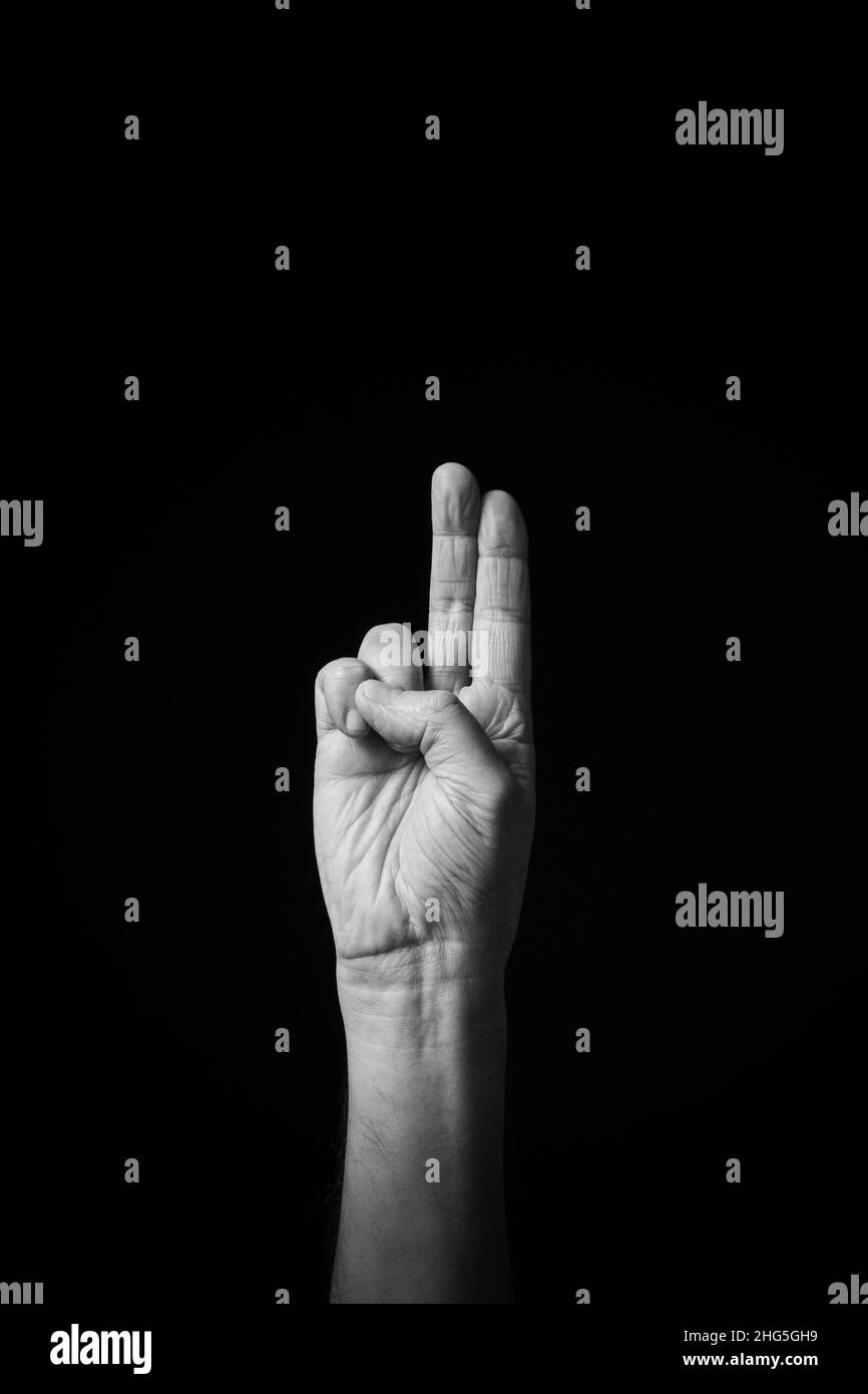 Immagine B+W drammatica del maschio mano Fingerspelling CSL cinese segno lingua lettera H isolato su sfondo scuro Foto Stock