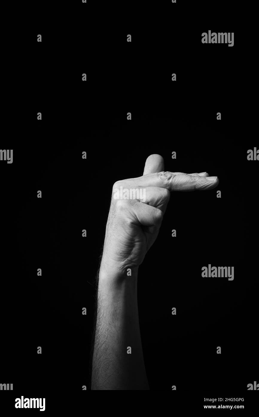 Immagine B+W drammatica del maschio mano Fingerspelling CSL cinese segno lingua lettera SH isolato su sfondo scuro Foto Stock