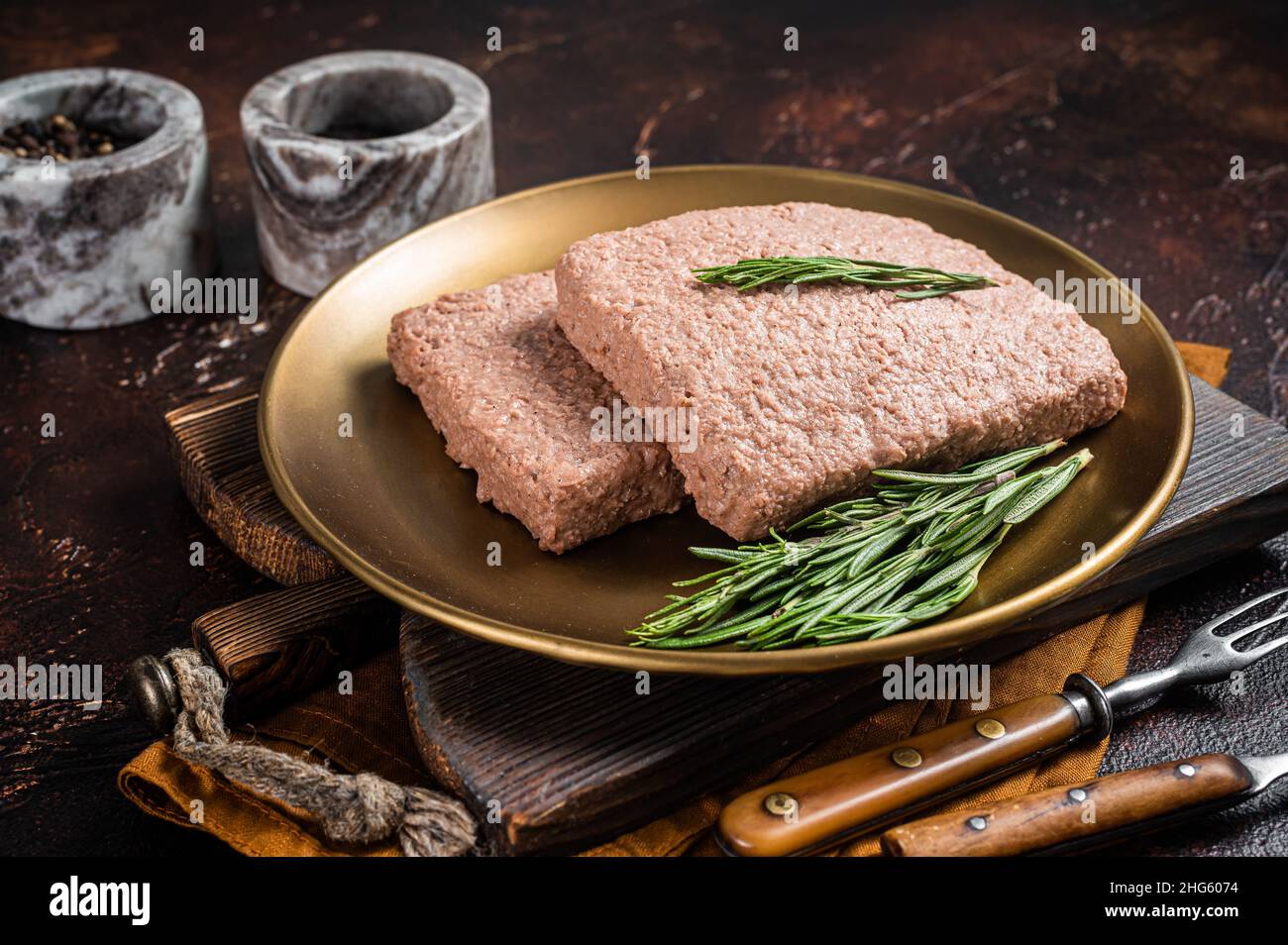 Carne fresca di trito di Veggie, carne cruda a base di piante con rosmarino. Sfondo scuro. Vista dall'alto Foto Stock