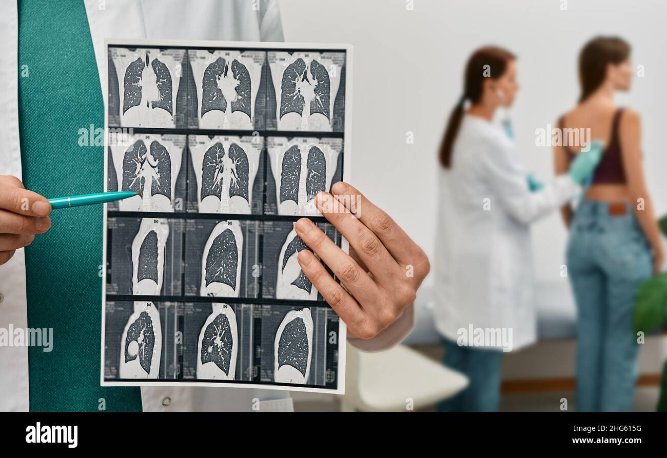 Pulmonologista che mostra TC scansione di polmoni femmina con polmonite su sfondo polmoni esame per paziente. Malattia polmonare, fibrosi polmonare Foto Stock