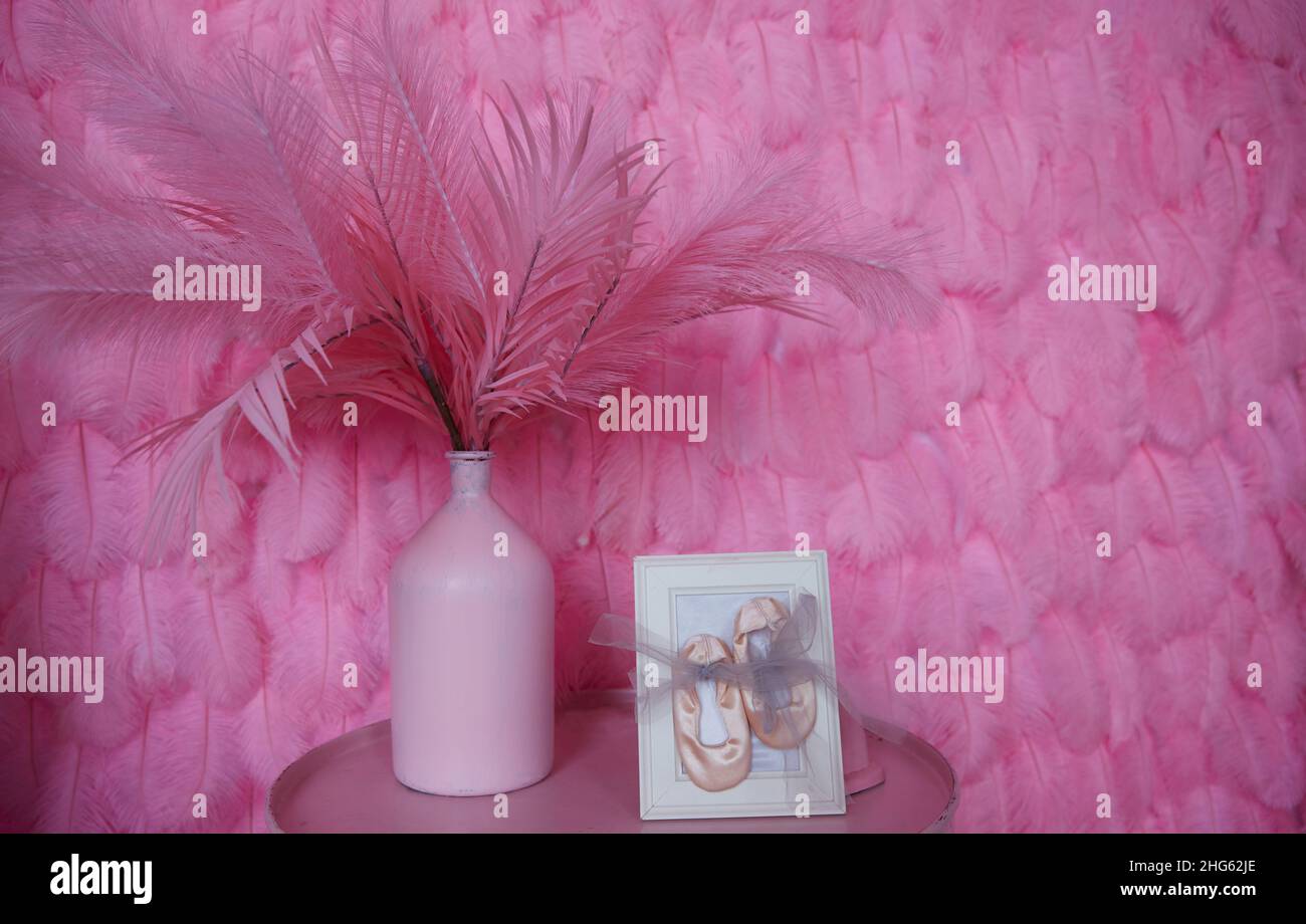 dettagli del design di interni domestici. Un muro di piume rosa e un vaso di piume su un comodino rotondo. Decorazione del soggiorno Foto Stock