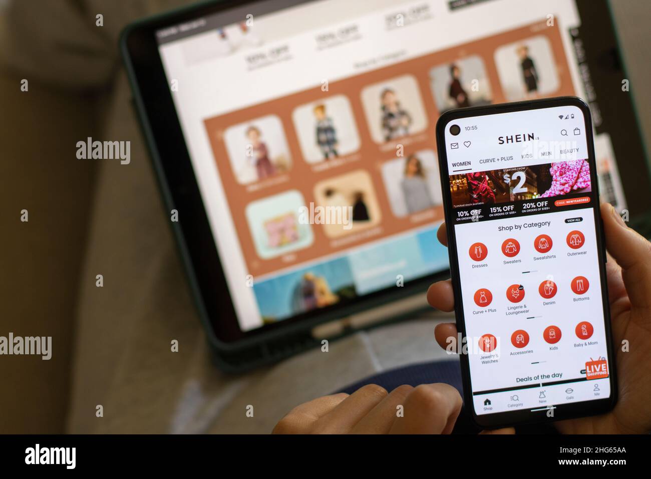 Una donna fa un negozio di abbigliamento per bambini tramite L'app SHEIN sul suo telefono. Shein è un rivenditore cinese di moda veloce online noto per il suo abbigliamento a prezzi accessibili. Foto Stock