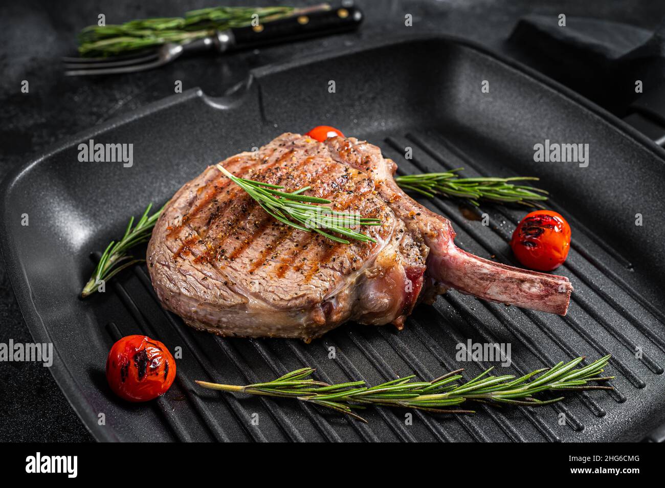 Bistecca di manzo alla griglia con costolette di Tomahawk (vitello) sulla griglia. Sfondo nero. Vista dall'alto Foto Stock