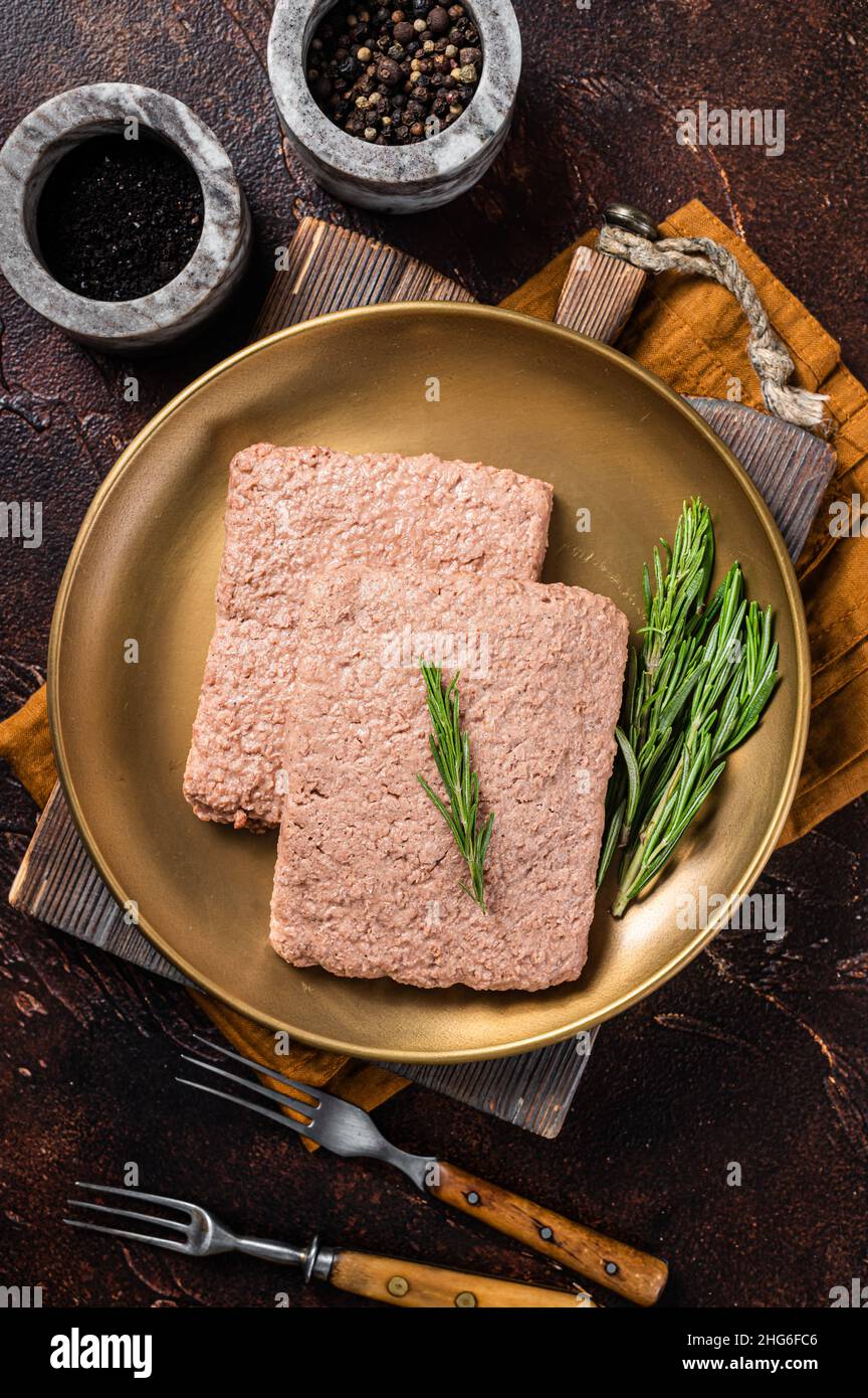 Carne fresca di trito di Veggie, carne cruda a base di piante con rosmarino. Sfondo scuro. Vista dall'alto Foto Stock