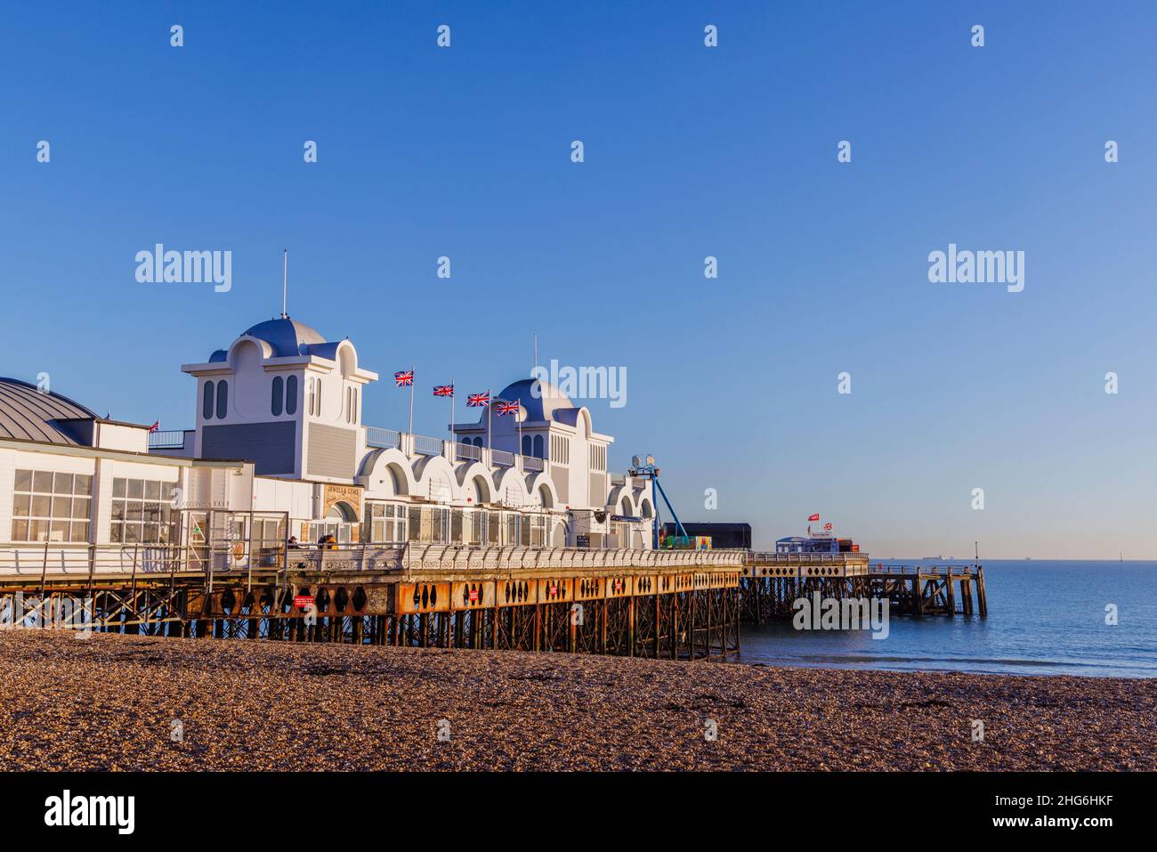 South Parade Pier sul lungomare e la spiaggia di pietra a Southsea, Portsmouth, Hampshire, costa meridionale Inghilterra in una giornata di sole con cielo blu nuvoloso Foto Stock