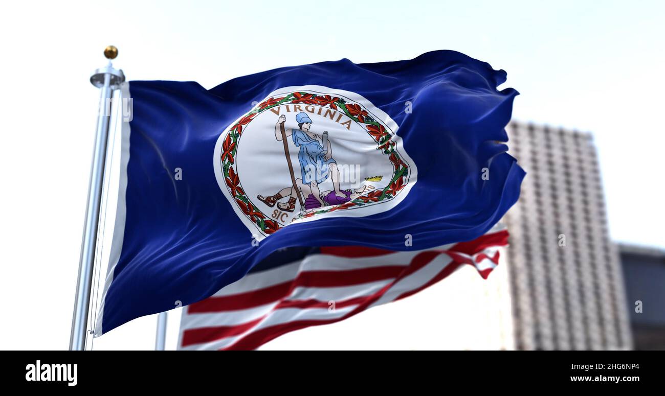 La bandiera dello stato americano della Virginia sventola nel vento con la bandiera americana sfocata sullo sfondo. La Virginia è stata ammessa nell'Unione il 2 giugno Foto Stock