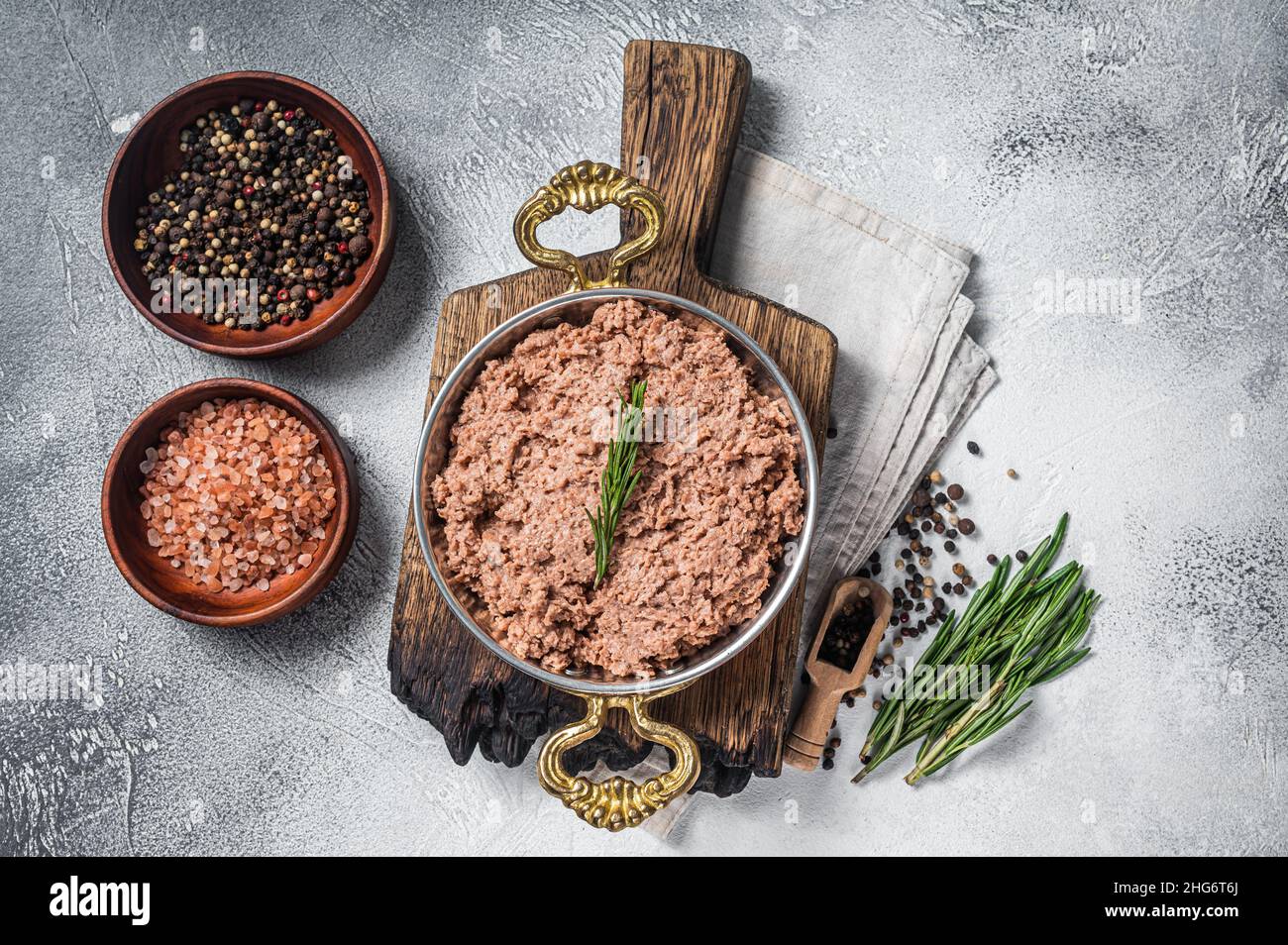 Carne di trita vegana non cotta, carne di pianta cruda con timo in padella. Sfondo bianco. Vista dall'alto Foto Stock