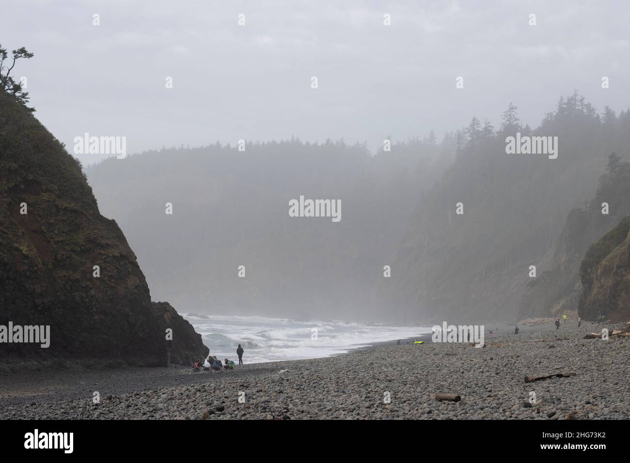 I visitatori della costa settentrionale dell'Oregon sono andati a fare un'oscillazione sulla breve spiaggia coperta da rocce lavate a riva con una bassa marea la domenica 16 gennaio 2022. Foto Stock