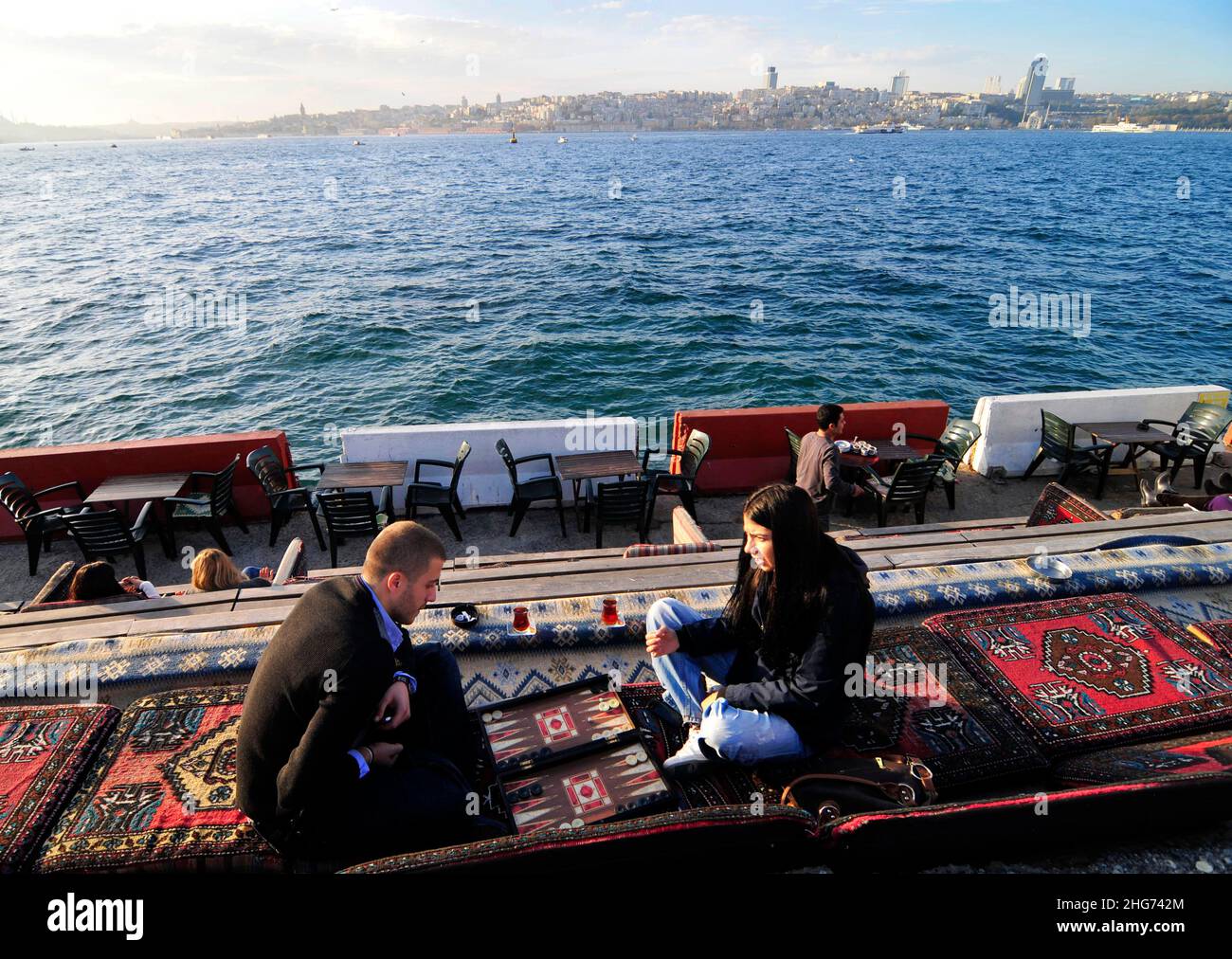 Una coppia turca che gioca a backgammon sul lungomare della Uskudar Coast Walkway lungo lo stretto del Bosforo nel lato asiatico di Istanbul, Turchia. Foto Stock