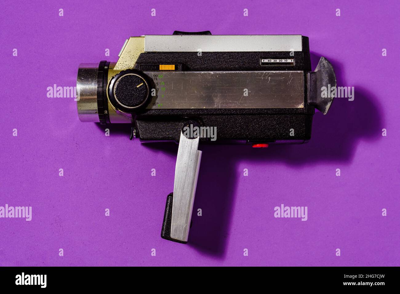 Un vecchio camcorder vintage per filmare su sfondo viola. Foto Stock