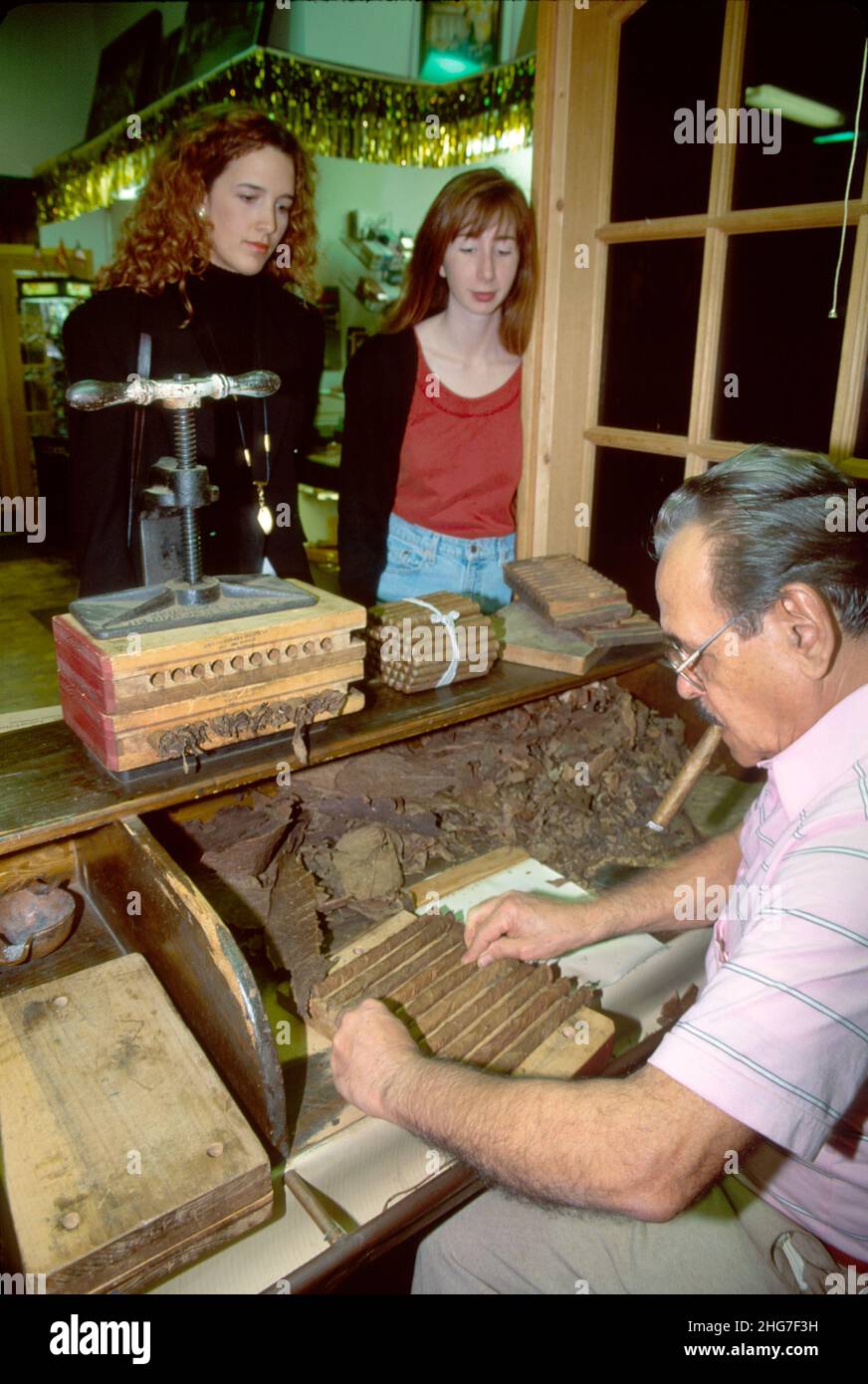 Florida Tampa Ybor City Square Tampa Rico Cigar Company, Cuban cigar roller working, Inside interior rolling, ispanici visitatori guardando uomo donne maschi Foto Stock