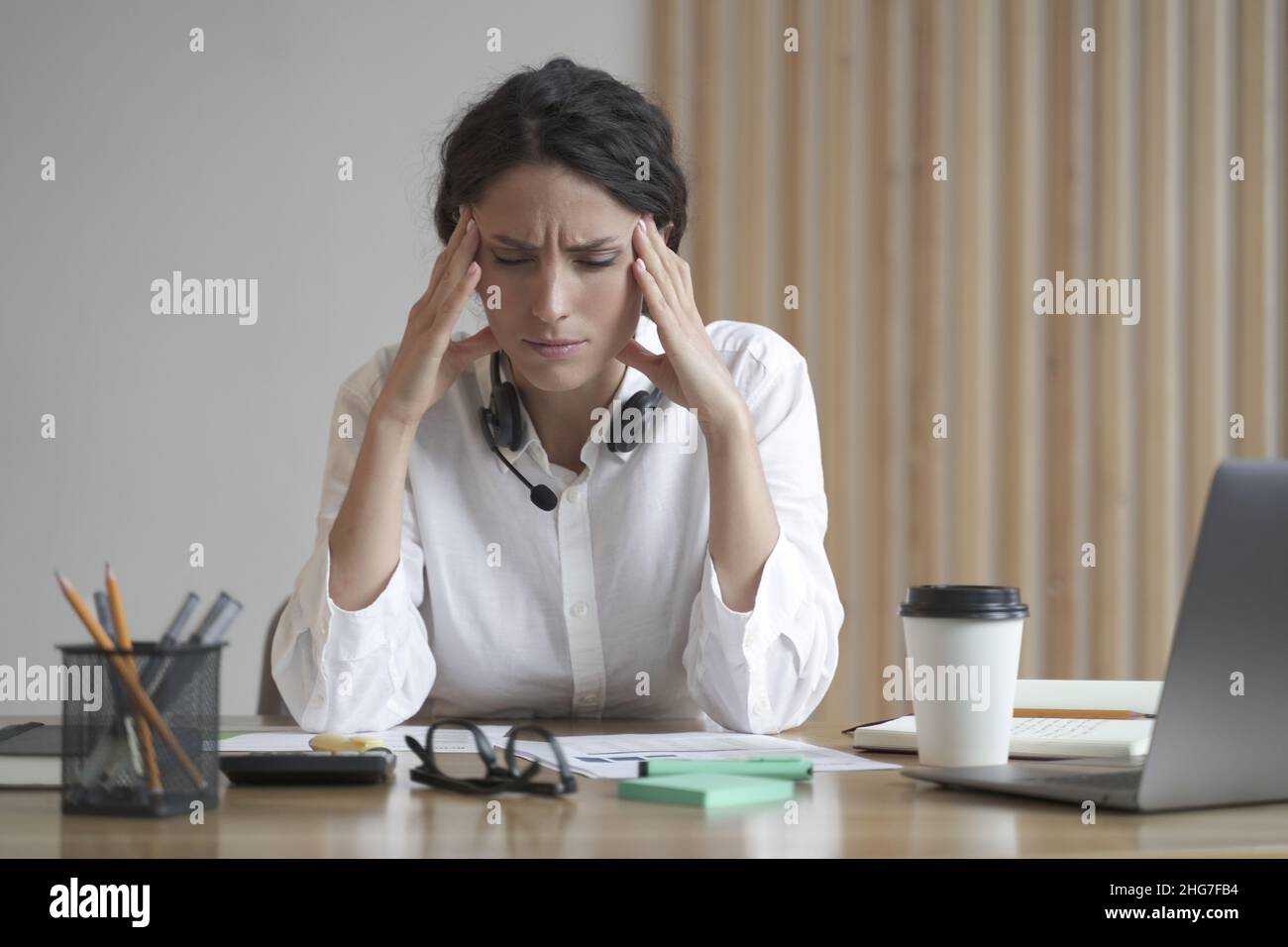 Stressata donna imprenditore che soffre di mal di testa massaggiando templi mentre si siede in ufficio a casa Foto Stock