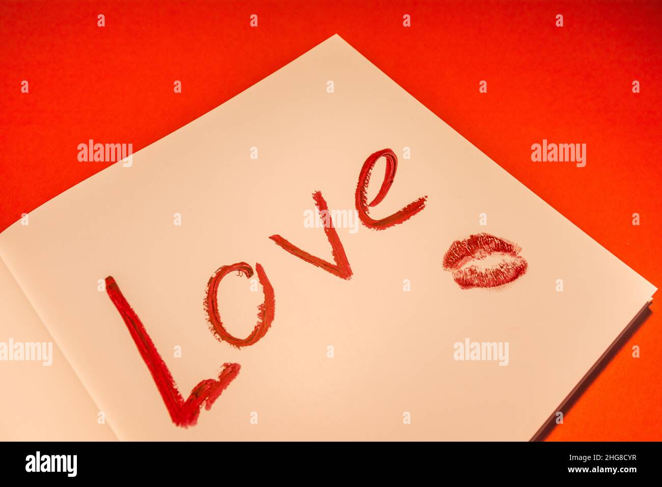 La parola amore è scritta in rossetto rosso su carta. San Valentino. Foto Stock