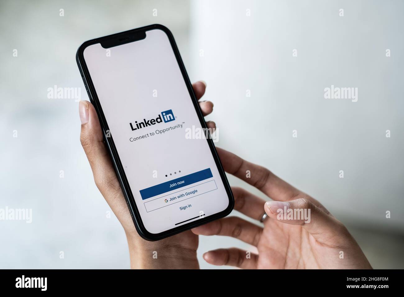 CHIANG mai, THAILANDIA - 15 GENNAIO 2022: Donna che tiene il telefono con l'applicazione LinkedIn sullo schermo. LinkedIn è un social network orientato alle aziende. Foto Stock