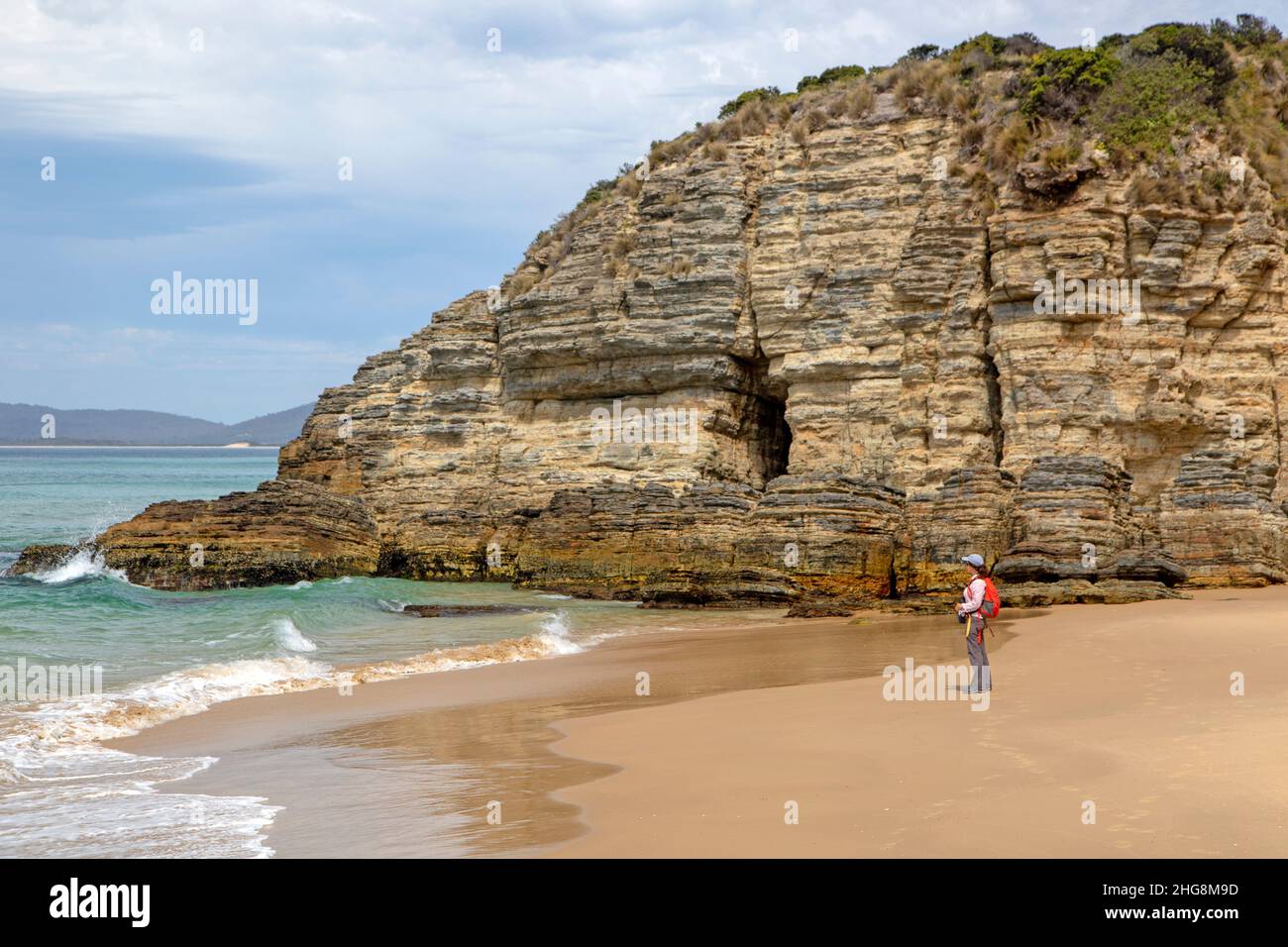 Donna su una spiaggia sulla Baia di Moorina, Isola di Bruny Foto Stock