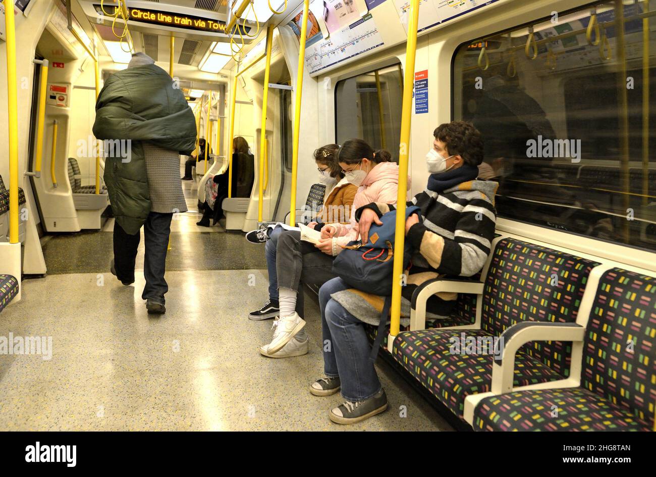 Londra, Inghilterra, Regno Unito. Passeggeri che indossano facemasks COVID su un treno sotterraneo, gennaio 2022 Foto Stock
