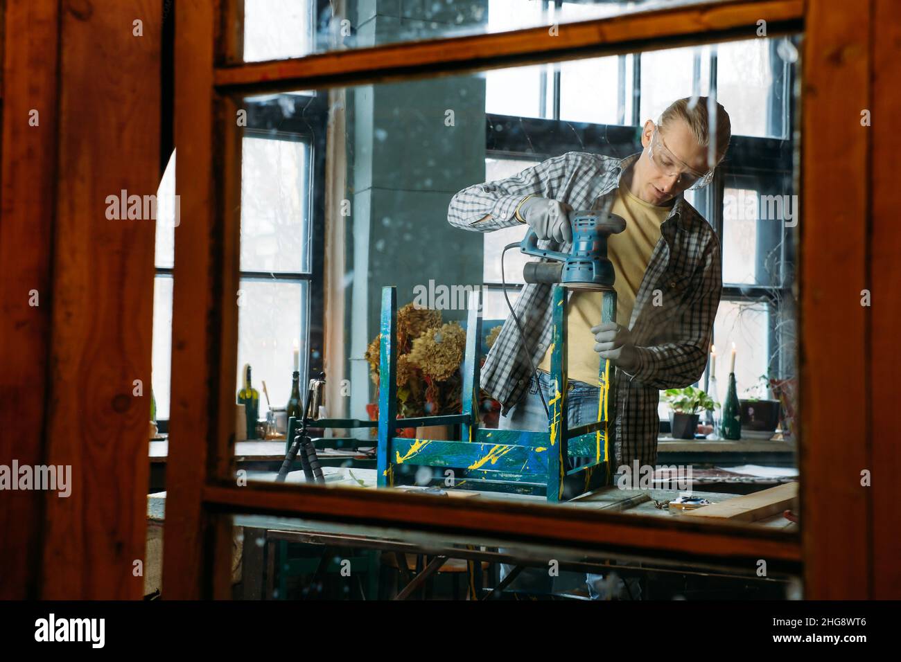 Uomo che lavora in officina, fa mobili, riutilizza vecchi materiali per nuovi prodotti. Consapevolezza nel consumo. Piccole imprese ecofriendly. Riciclaggio Foto Stock