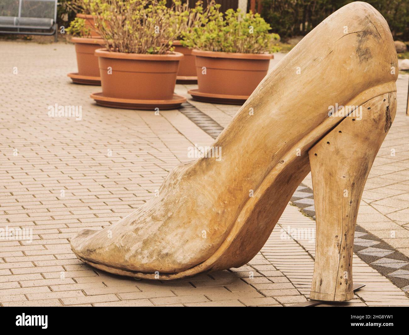 Scarpa in legno come decorazione in una strada dello shopping. Moda dal legno. Scarpa oversize. Interessante artigianato in legno Foto Stock