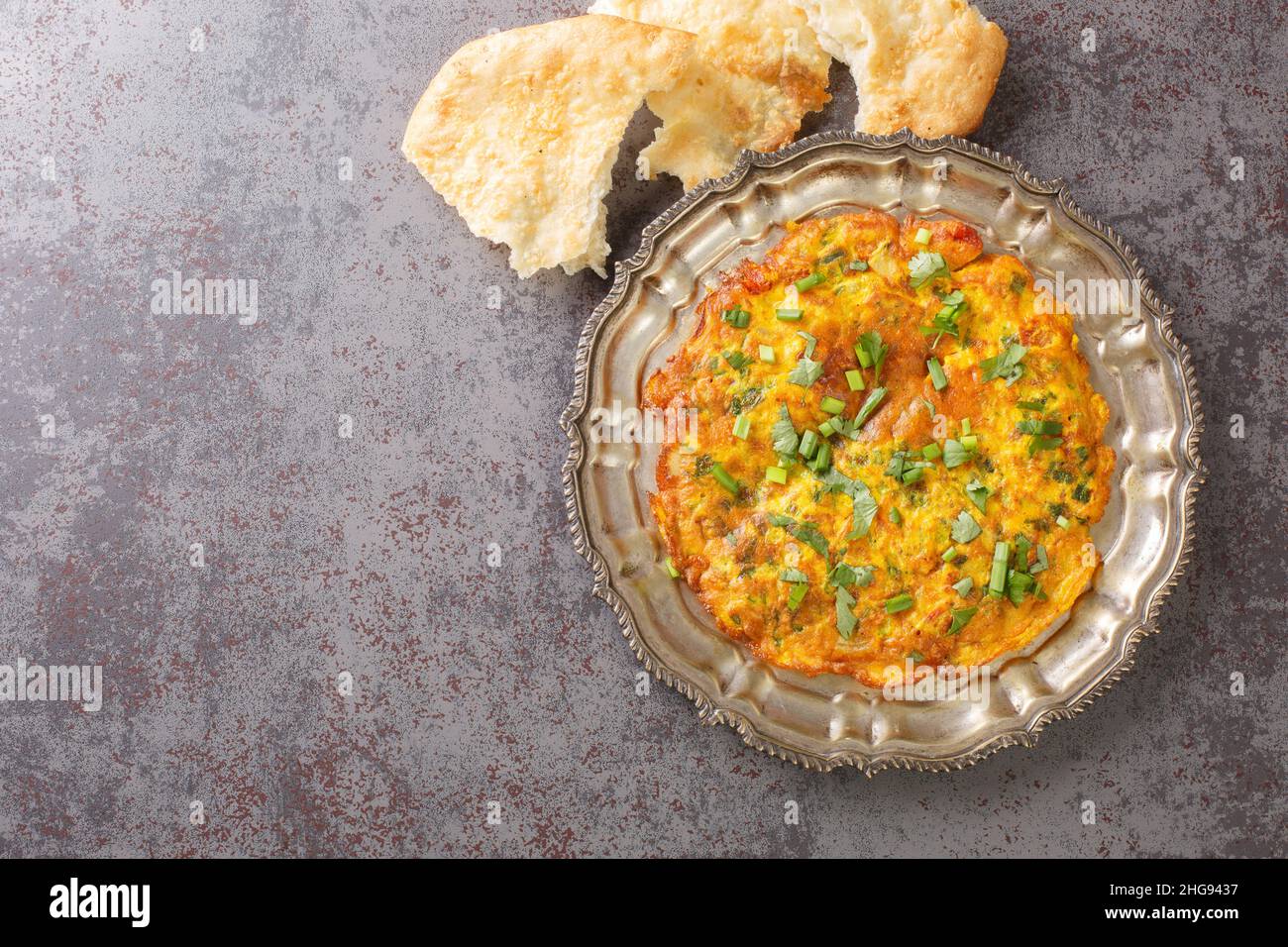 Popolare ricetta indiana nepalese Masala Omelet servita sul piatto sul tavolo. Vista dall'alto orizzontale Foto Stock