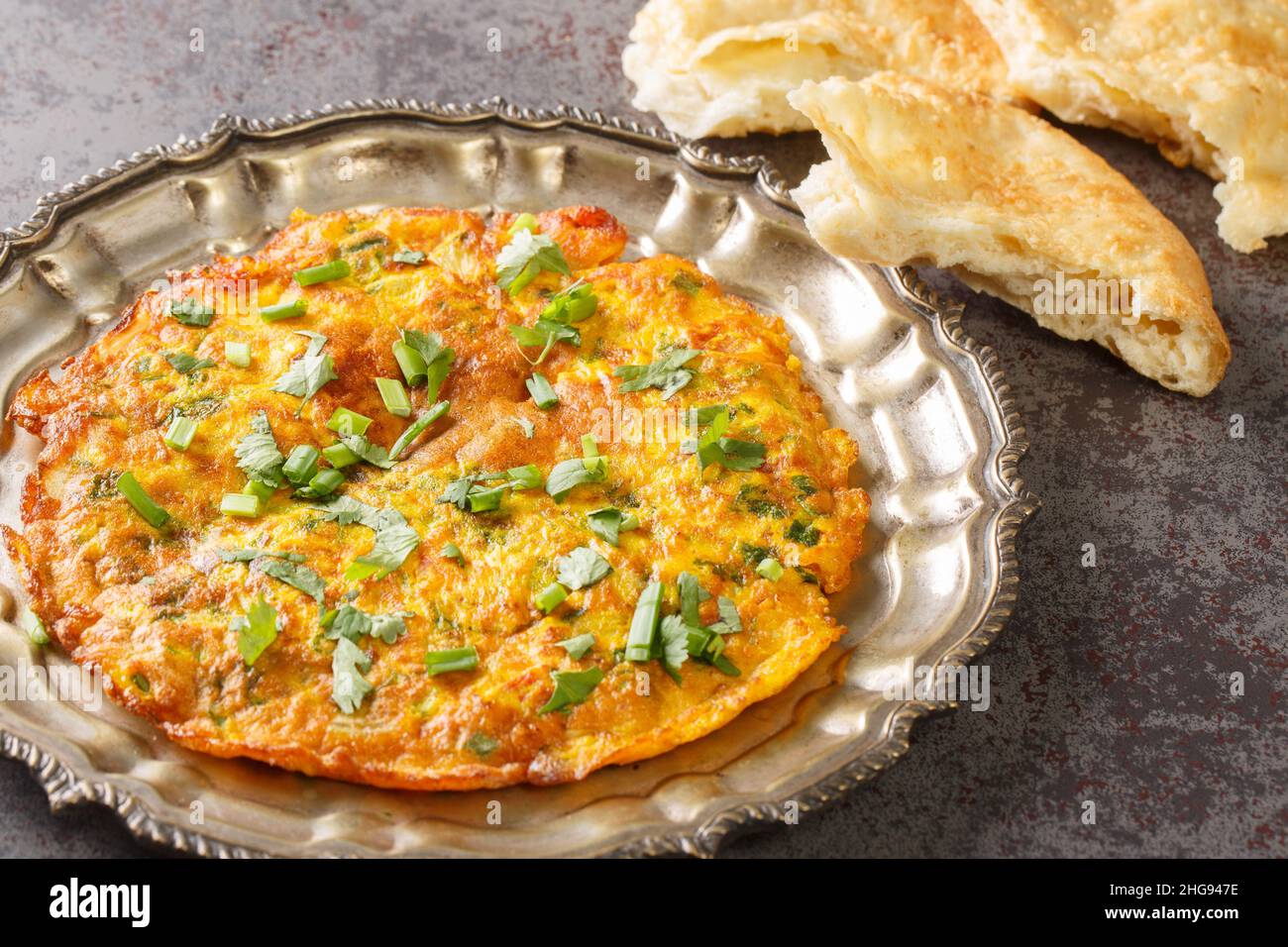 Mescolare l'omelette di Veggie fritta con verdure miste. Indian Nepalese stile Masala Omelet primo piano nel piatto sul tavolo. Orizzontale Foto Stock