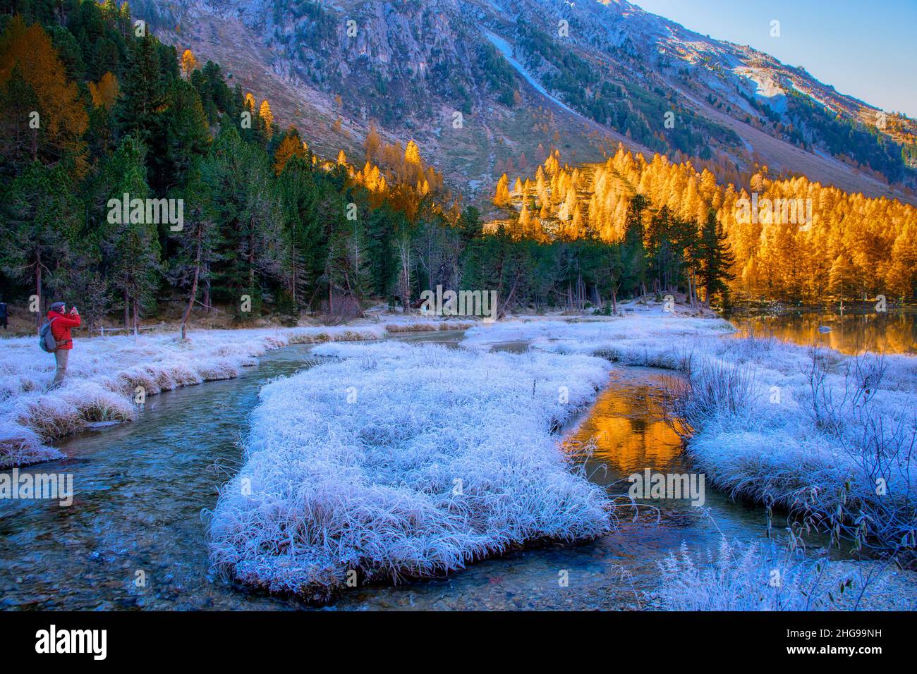 Uomo che scatta una foto con un cellulare in un paesaggio invernale gelido, Palpuogna, Graubunden, Svizzera Foto Stock