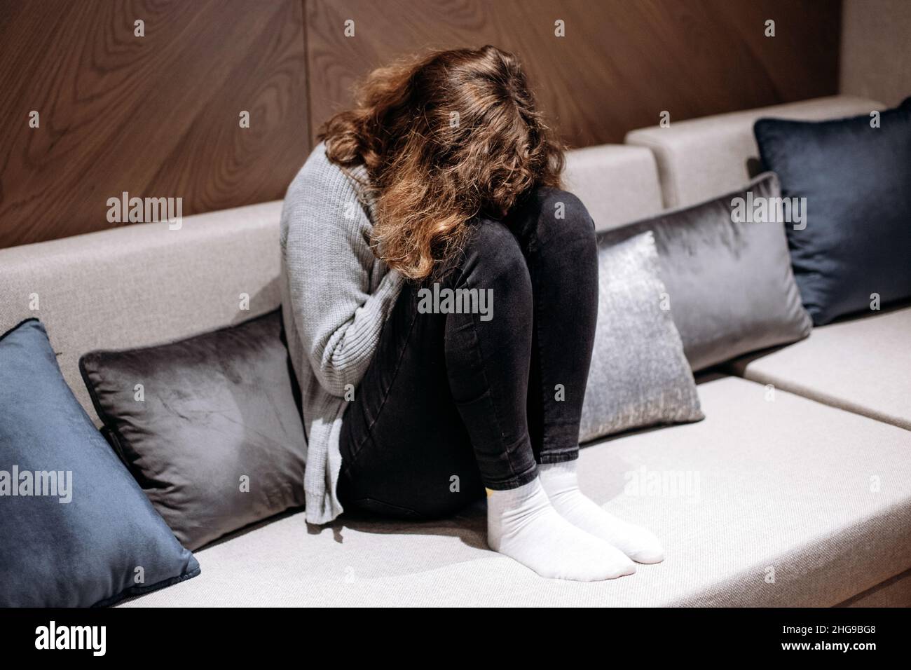 Ragazza adolescente che piange sul divano. Pubertà e depressione Foto Stock