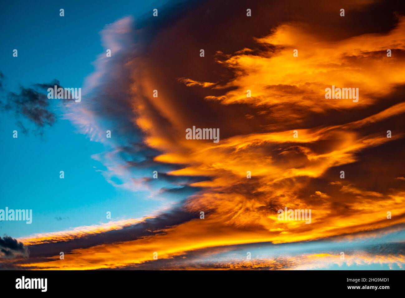 Incredibile tramonto sulla nuvola arancione contro cieli blu durante il periodo invernale sulla costa mediterranea sfondo carta da parati desktop Foto Stock