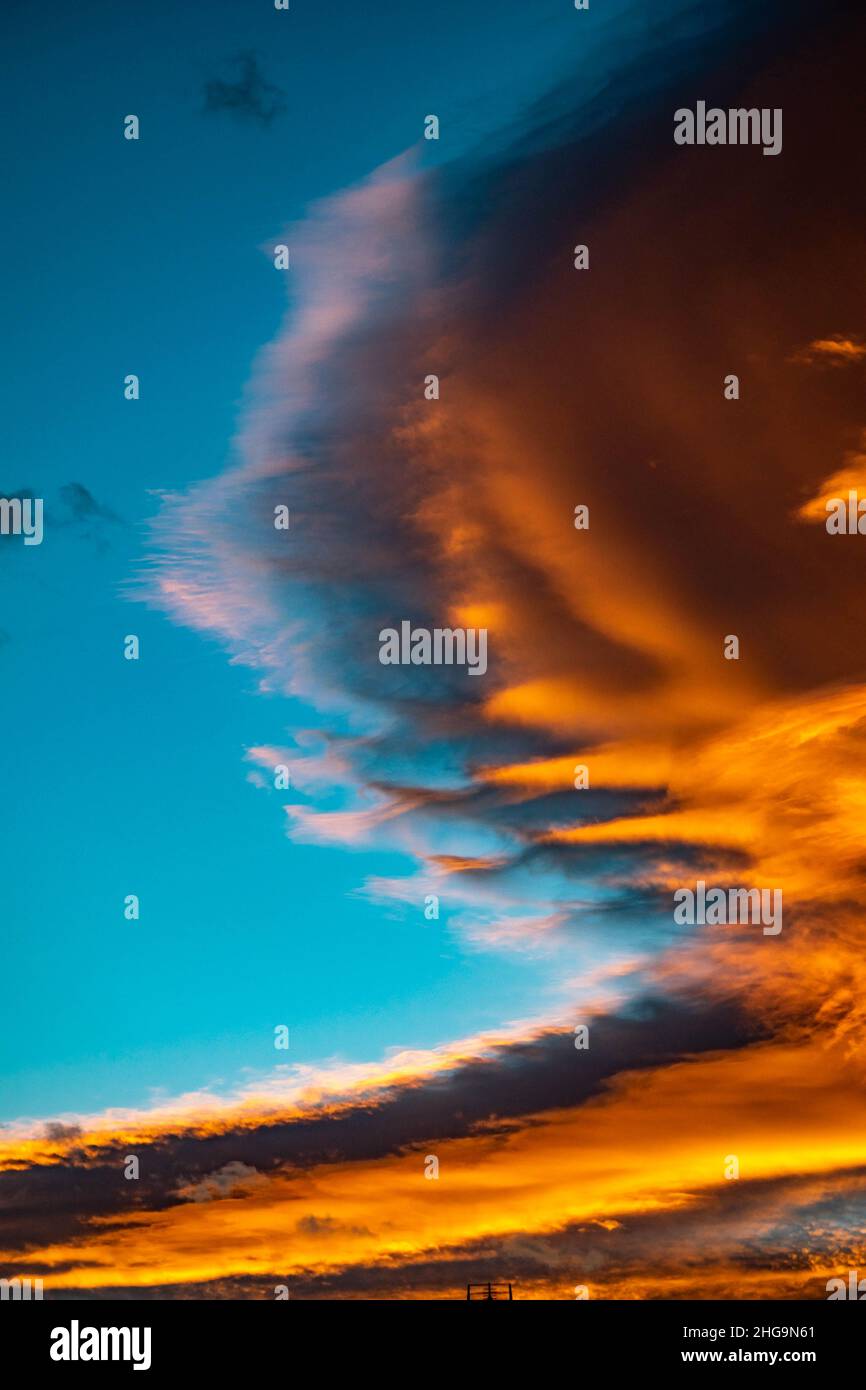 Un ritratto sfondo immagine di sfondo di una nube di colore arancione dorato sorgere del sole sulla costa mediterranea di Marbella nella Costa del Sol Foto Stock