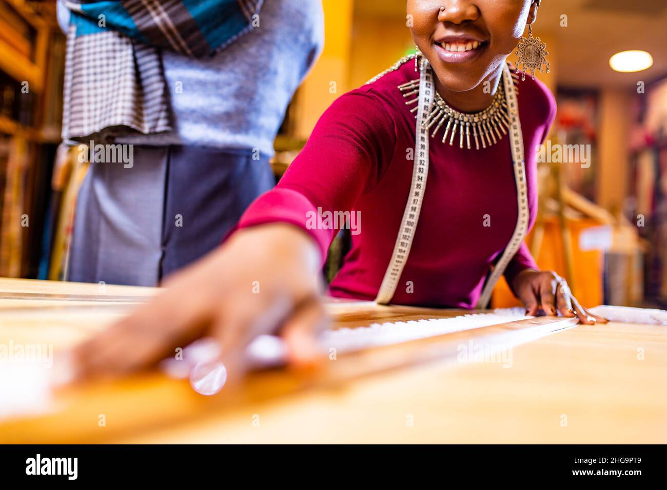 donna salewoman business con pelle scura che lavora presso il negozio di tessuti Foto Stock