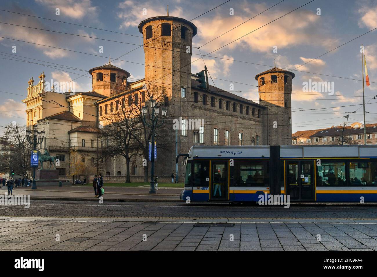 Un tram che passa di fronte a Casaforte di Acaja e Palazzo Madama in Piazza Castello al tramonto, Torino, Piemonte, Italia Foto Stock