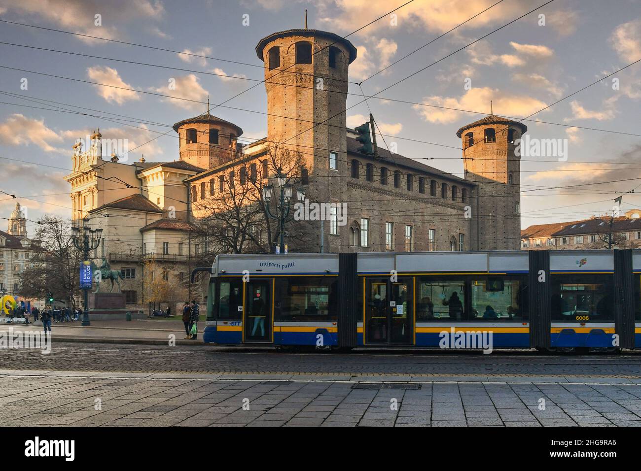 Un tram che passa di fronte a Casaforte di Acaja e Palazzo Madama in Piazza Castello al tramonto, Torino, Piemonte, Italia Foto Stock