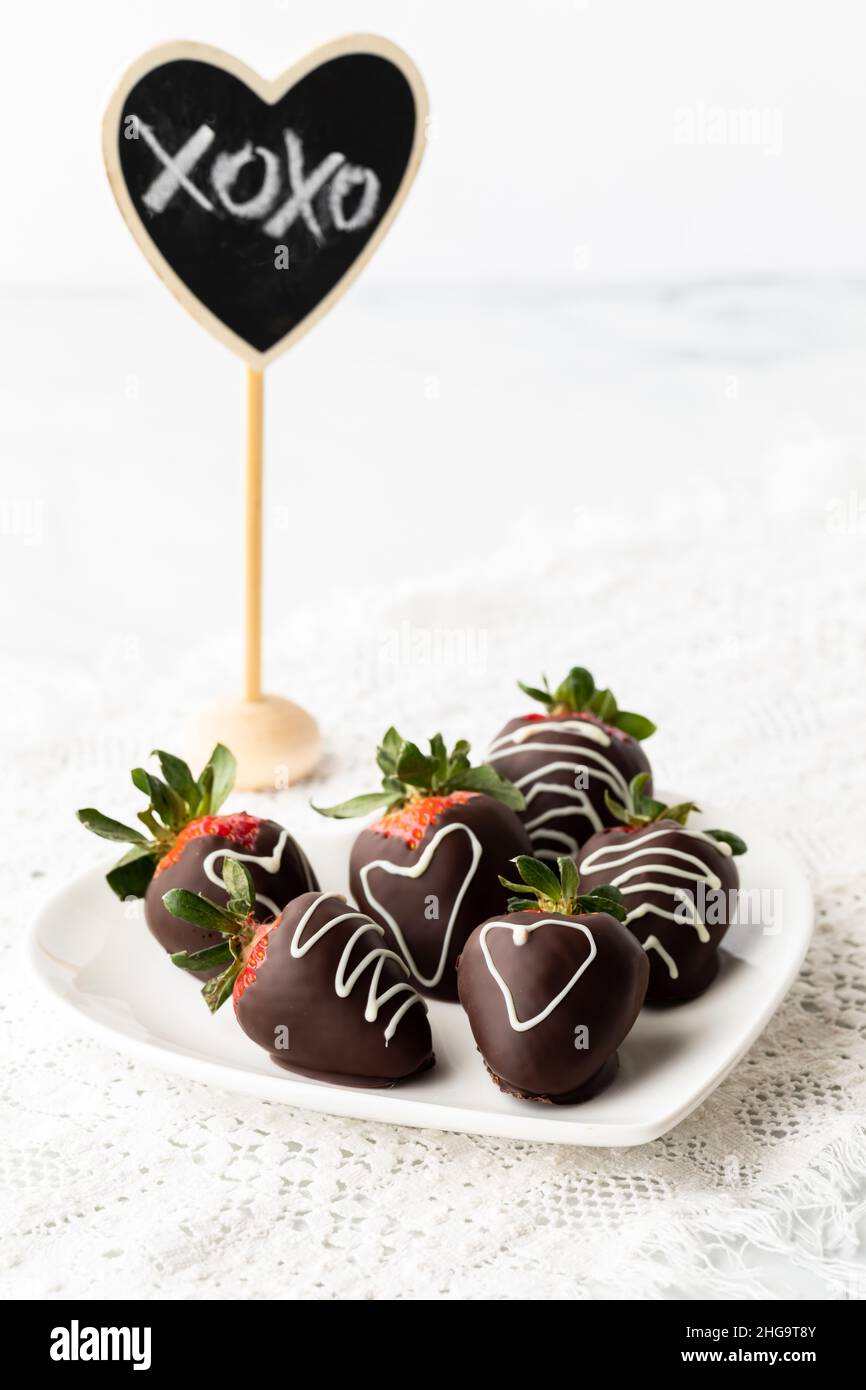 Fragole ricoperte di cioccolato per San Valentino con una nota speciale dietro. Foto Stock