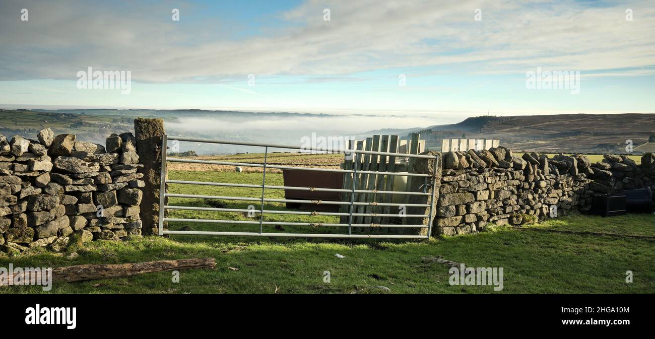 Lasciato in un muro di pietra arenaria, un cancello fattoria barred 7 dà accesso al pascolo brughiera Foto Stock