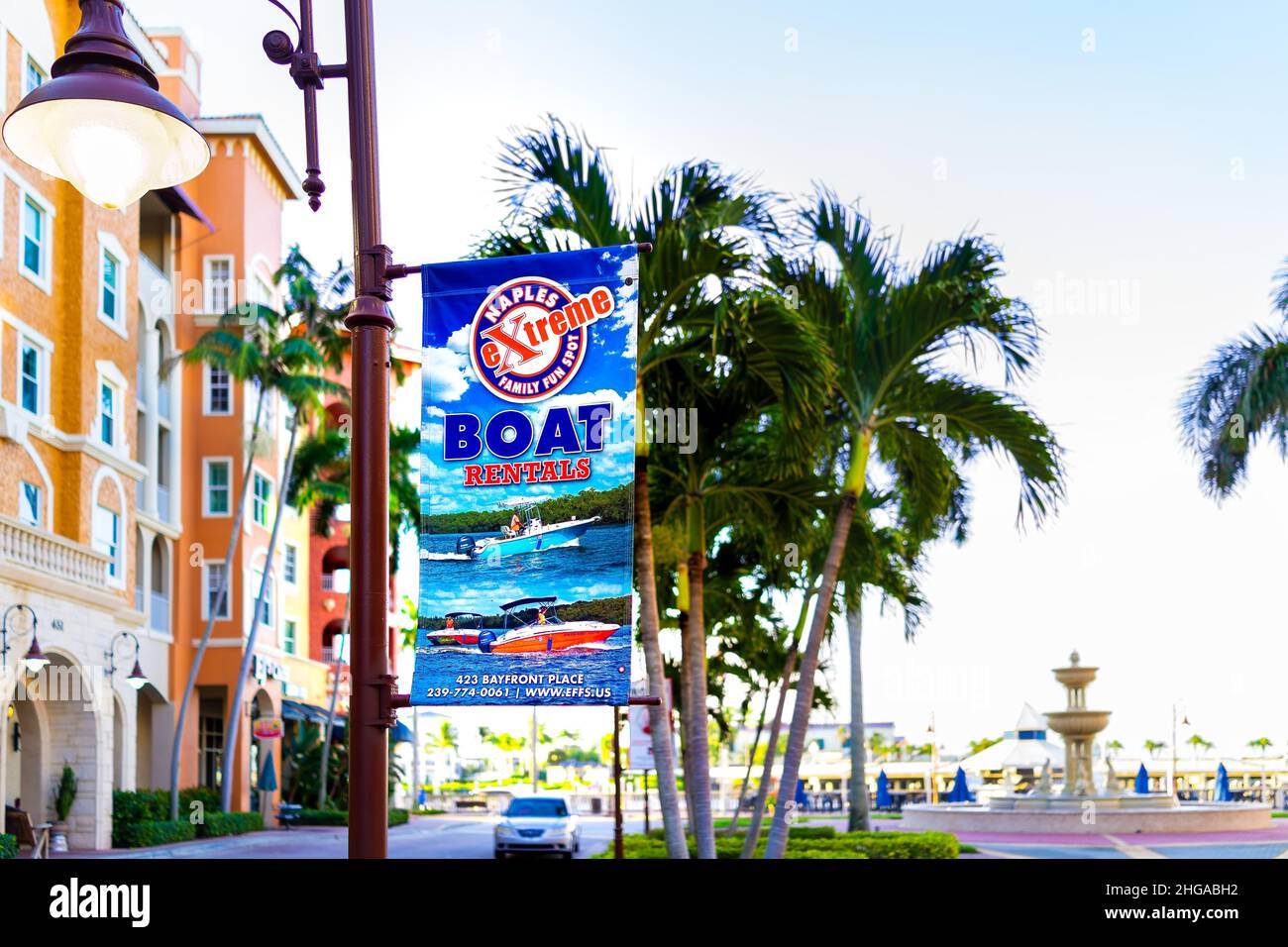 Napoli, USA - 13 settembre 2021: Napoli, Florida Bayfront Place Center con cartello per Extreme business società noleggio barche con palme e acqua Foto Stock
