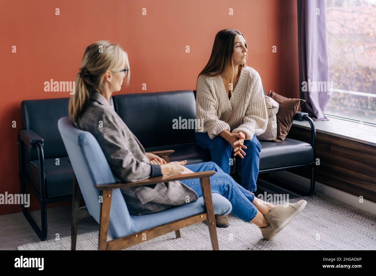 Una donna triste sofferente in visita ad una psicologa parla dei suoi problemi. Foto Stock