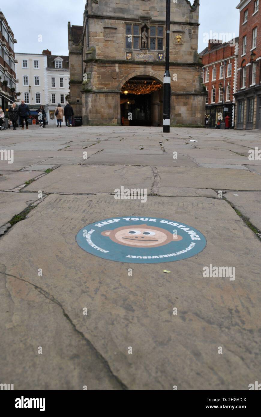 Una scena di strada della Piazza a Shrewsbury che mostra 'Mantieni la tua distanza' sul marciapiede Foto Stock