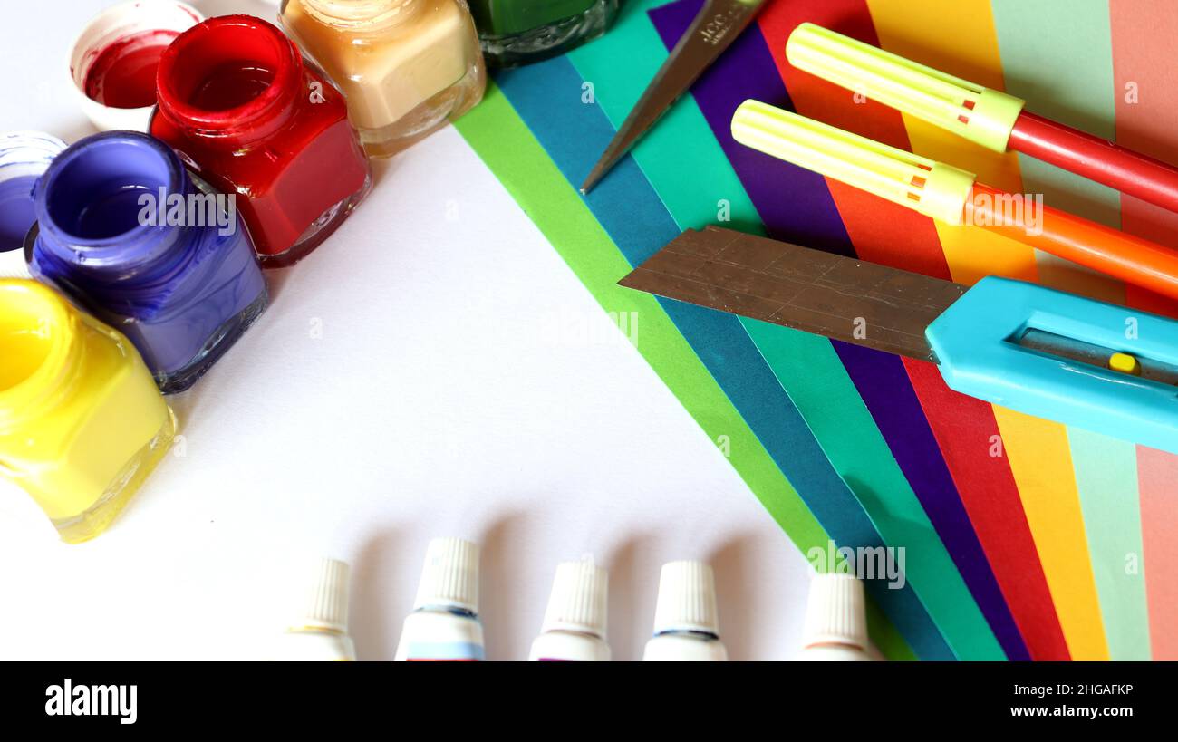 Opera d'arte, carta colorata, tubo colorato, penna e coltello su sfondo bianco Foto Stock